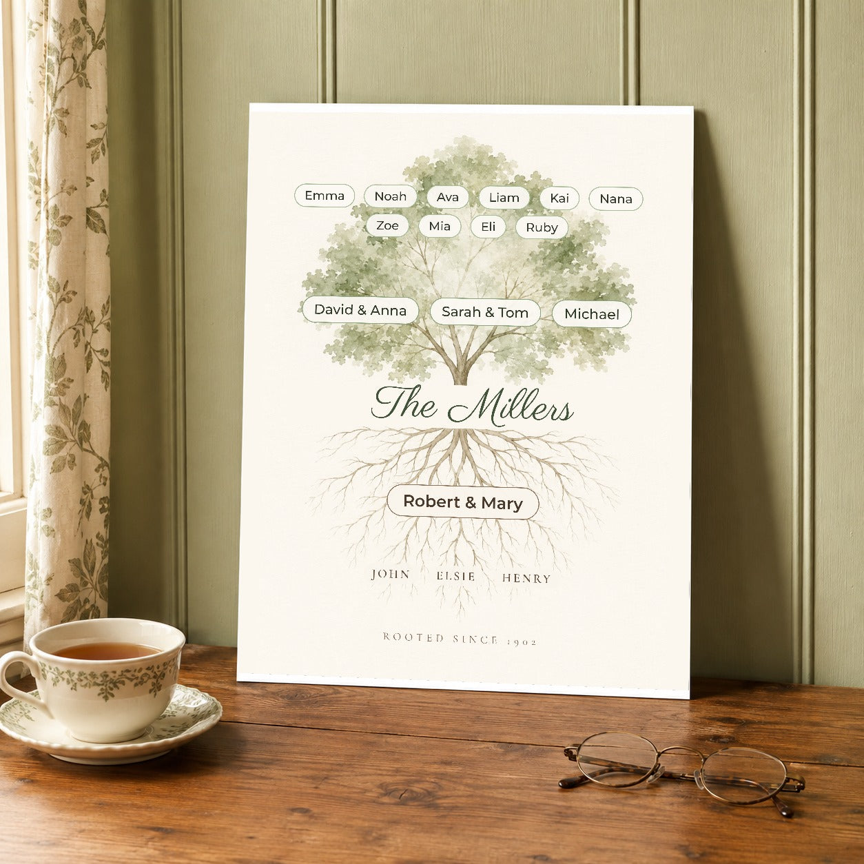 The unframed roots and branches family print resting on a wooden table beside a teacup and reading glasses