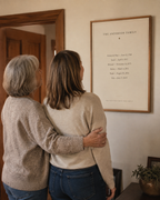 A mother and daughter looking at their newly hung family dates print