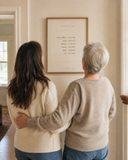 A mother and daughter looking at their newly hung family dates print