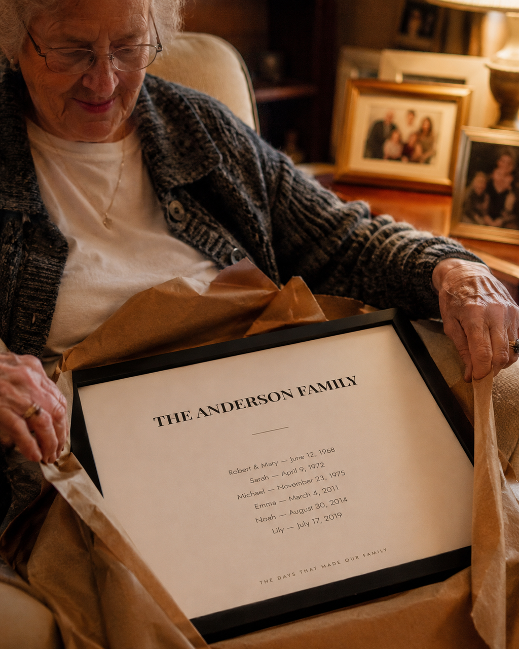 A woman in her seventies unwrapping the framed family dates print as a gift